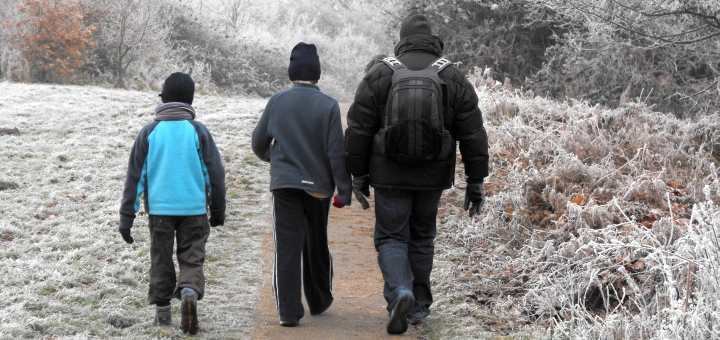 Family group walking in frosty countryside. Photograph by Tlst